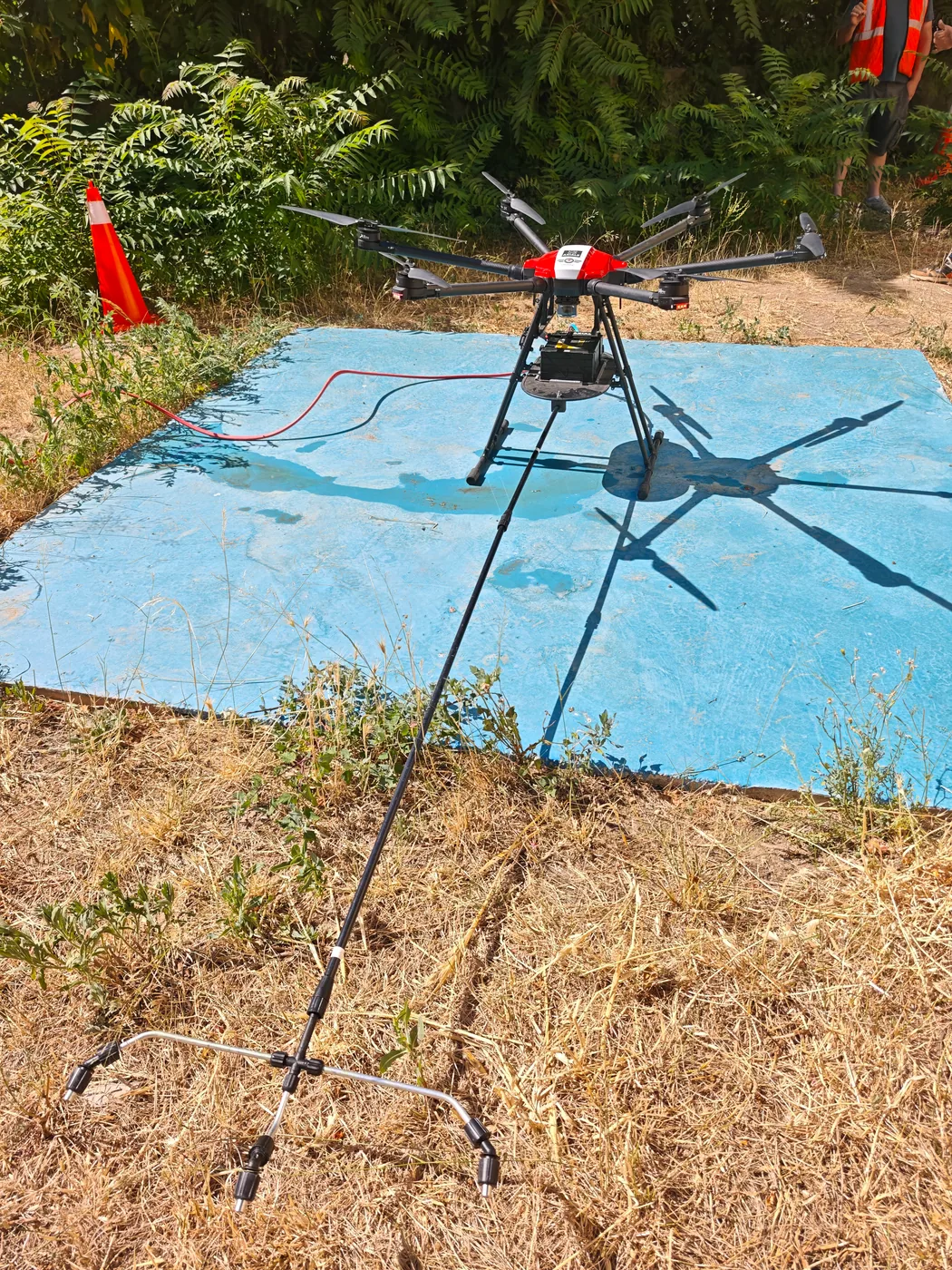 Drone de pulvérisation AltiWash posé sur son aire de décollage, balisage en place