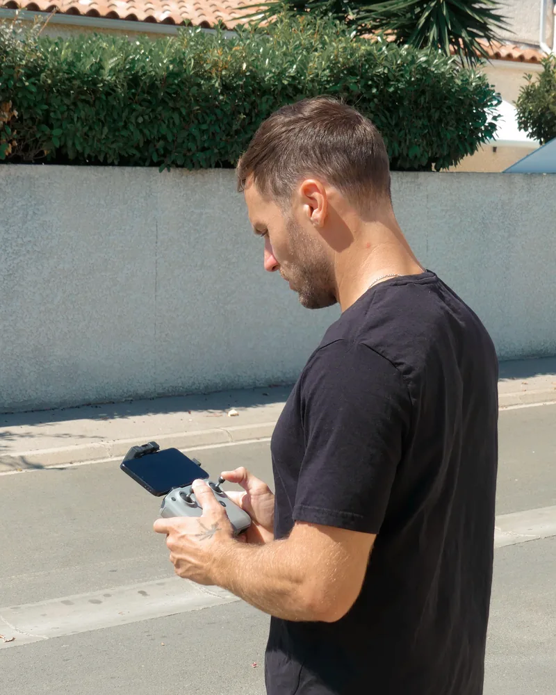 Télépilote AltiWash aux commandes du drone de pulvérisation, opérateur au sol
